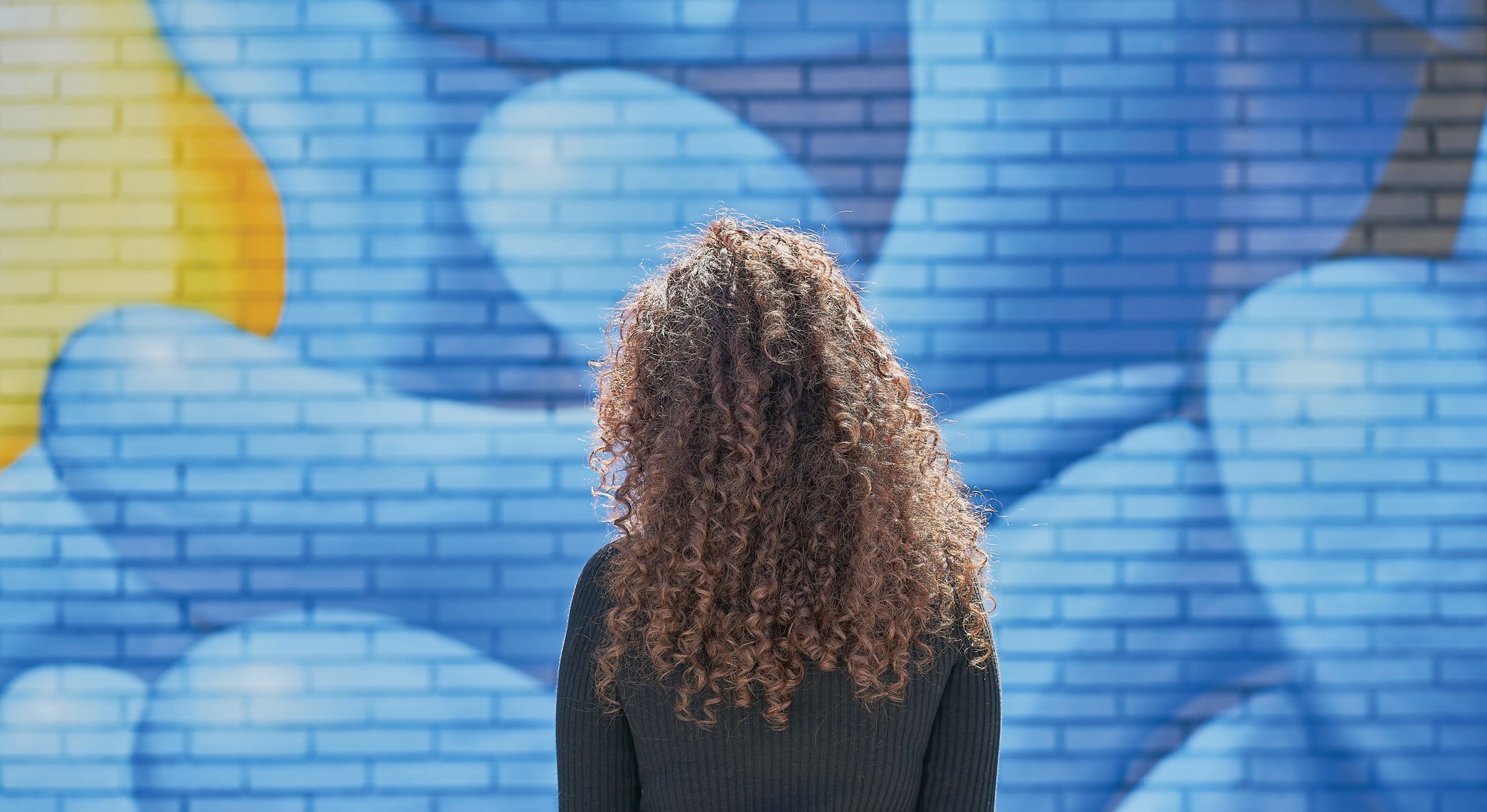 a woman examines a mural